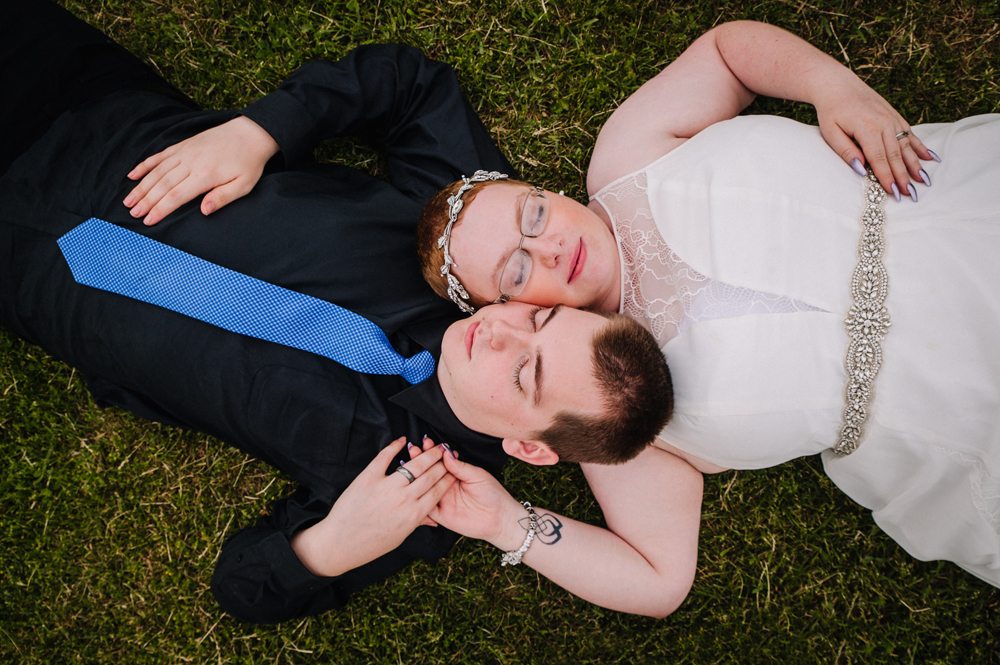 couple laying in grass wedding photo